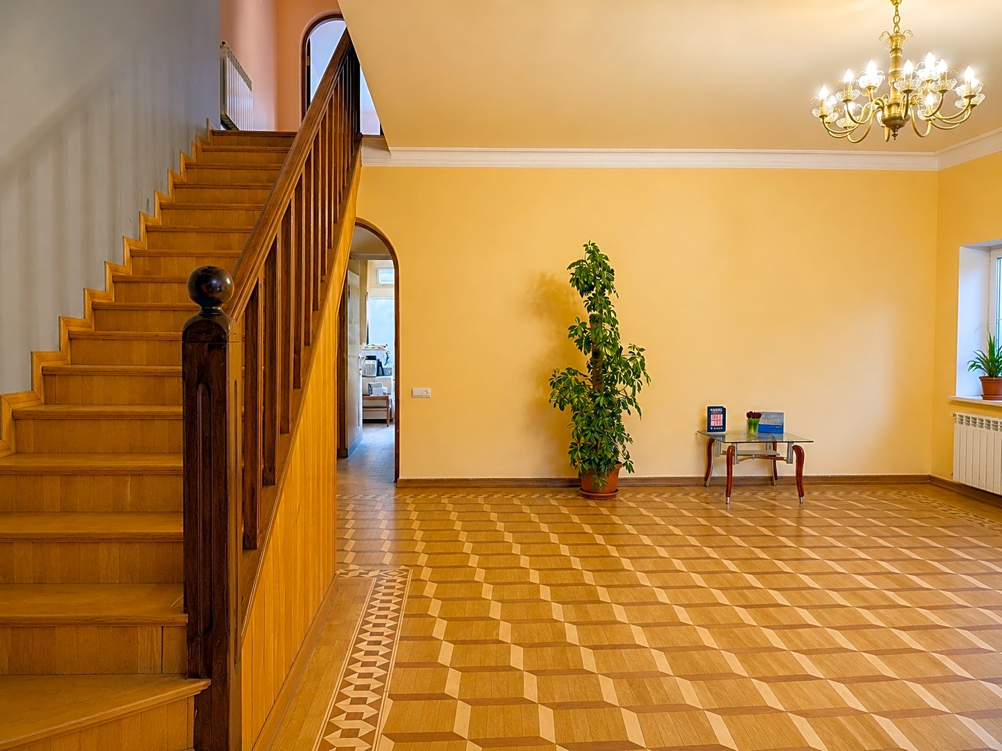 The chandelier-lit staircase hall with parquet floor